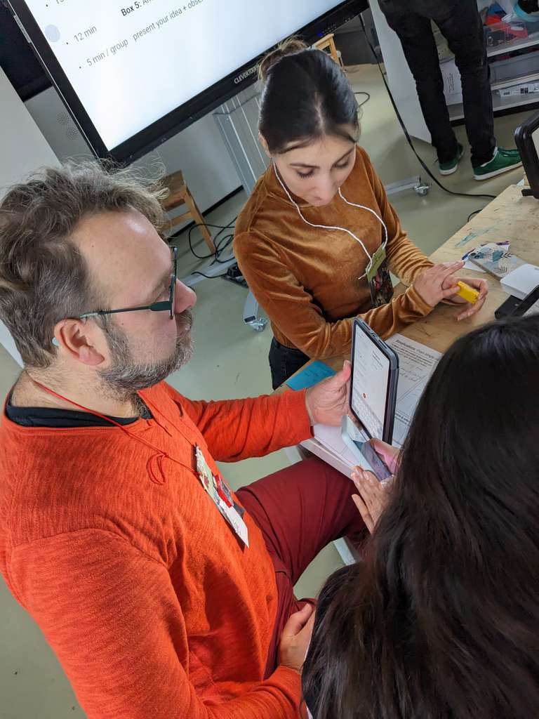 Zwei Workshop-Teilnehmer sehen sich Sensordaten auf dem Tablet genauer an